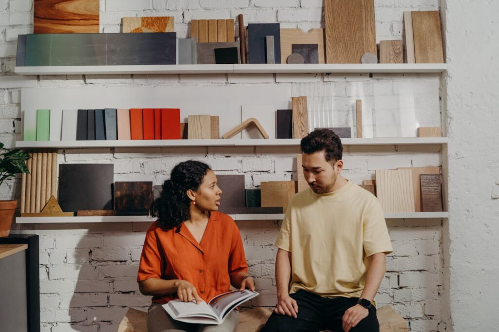 Woman Pointing at a Catalog while Talking to a Man